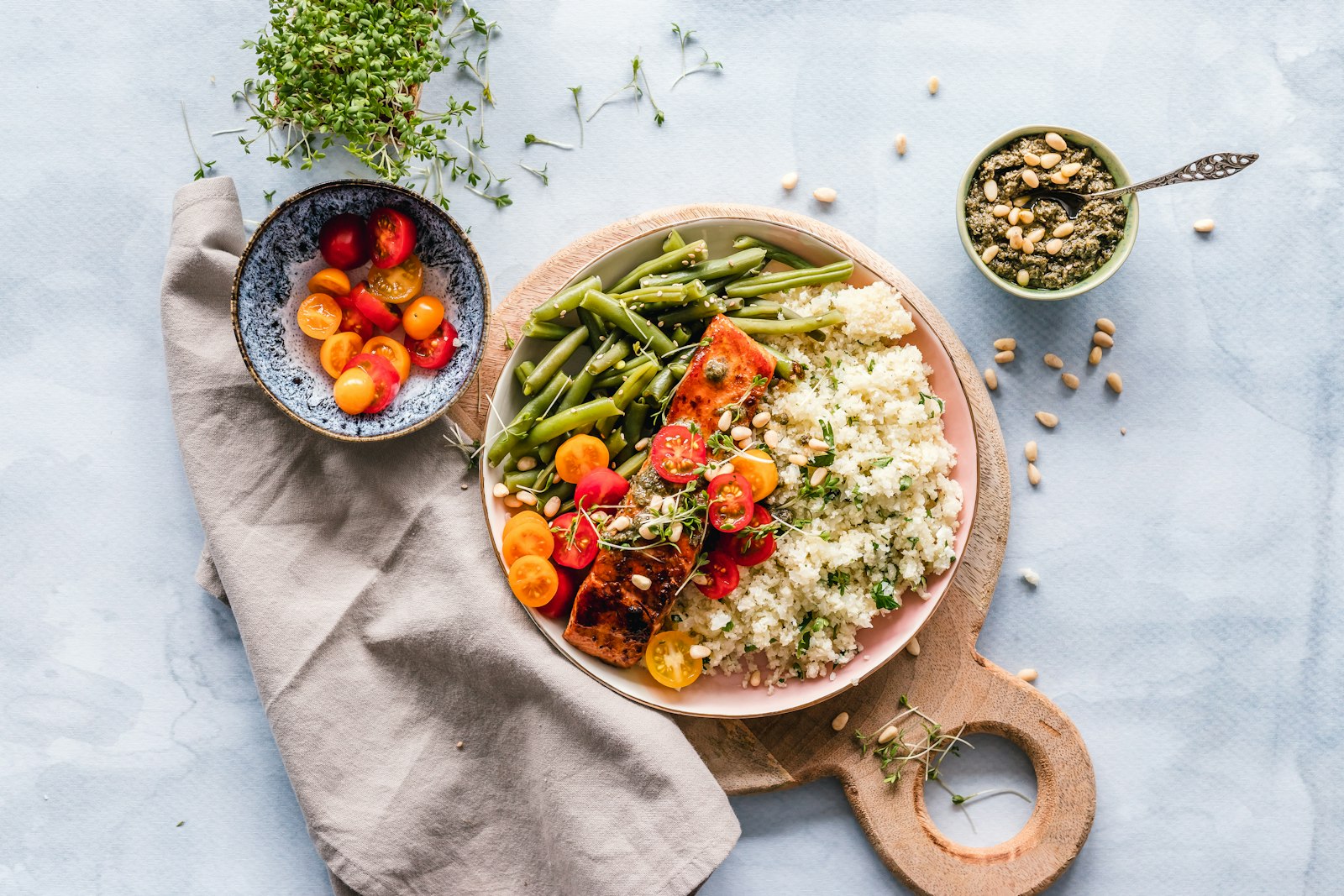 A served bowl of food on a wooden board with fresh sides
